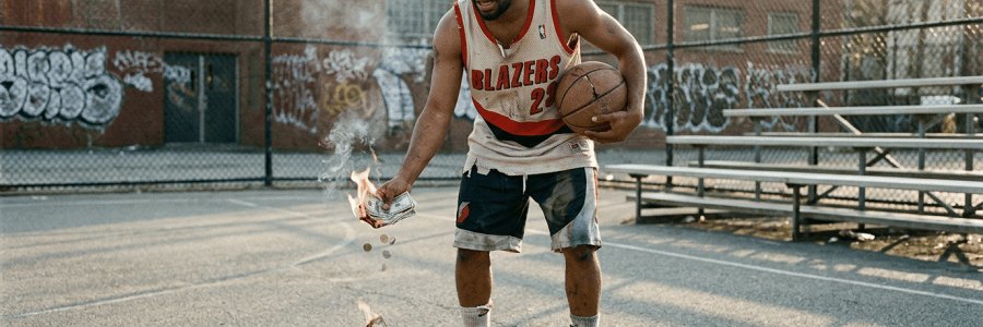 Basketball player in BLAZERS number 23 jersey burns dollar bills